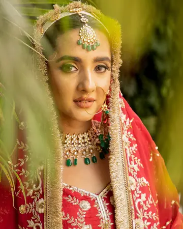 Close portrait of the bride framed by blurred green fronds