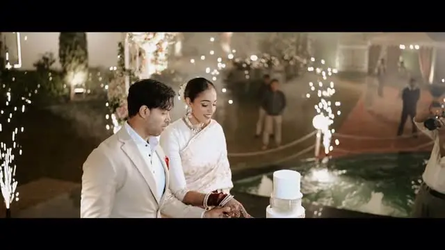 A still from Kavita and Anmol's reception film: the couple cutting their cake under sparklers