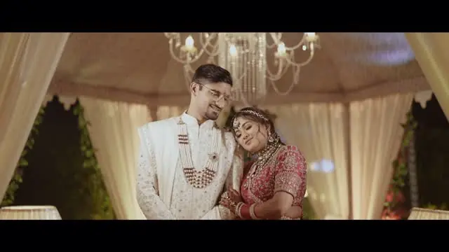 A still from Vaibhav and Bhavya's wedding film: the couple seated under a chandelier