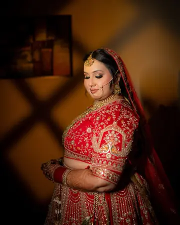 Gauri looks down, a diamond pattern of shadow on the wall behind her
