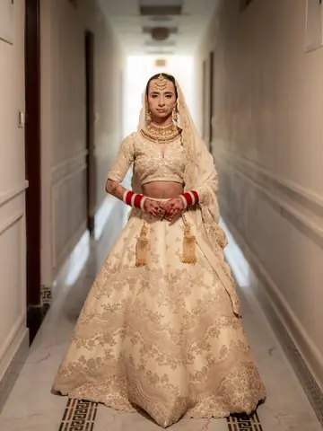 Mukta stands at the end of a long, softly lit hotel corridor