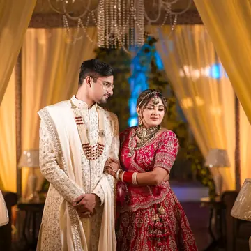Bhavya leans on Vaibhav's shoulder, eyes half closed, warm curtains behind