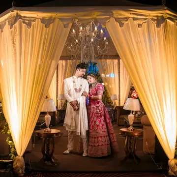 The whole gold canopy glowing at night, the couple small at its centre